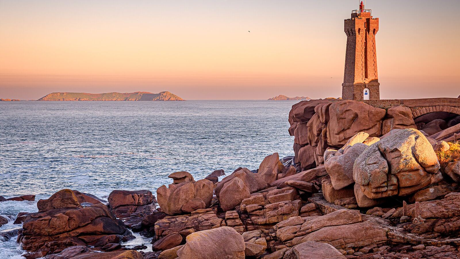 Mean Ruz lighthouse among the pink granite rocks of Ploumanac'h at sunset